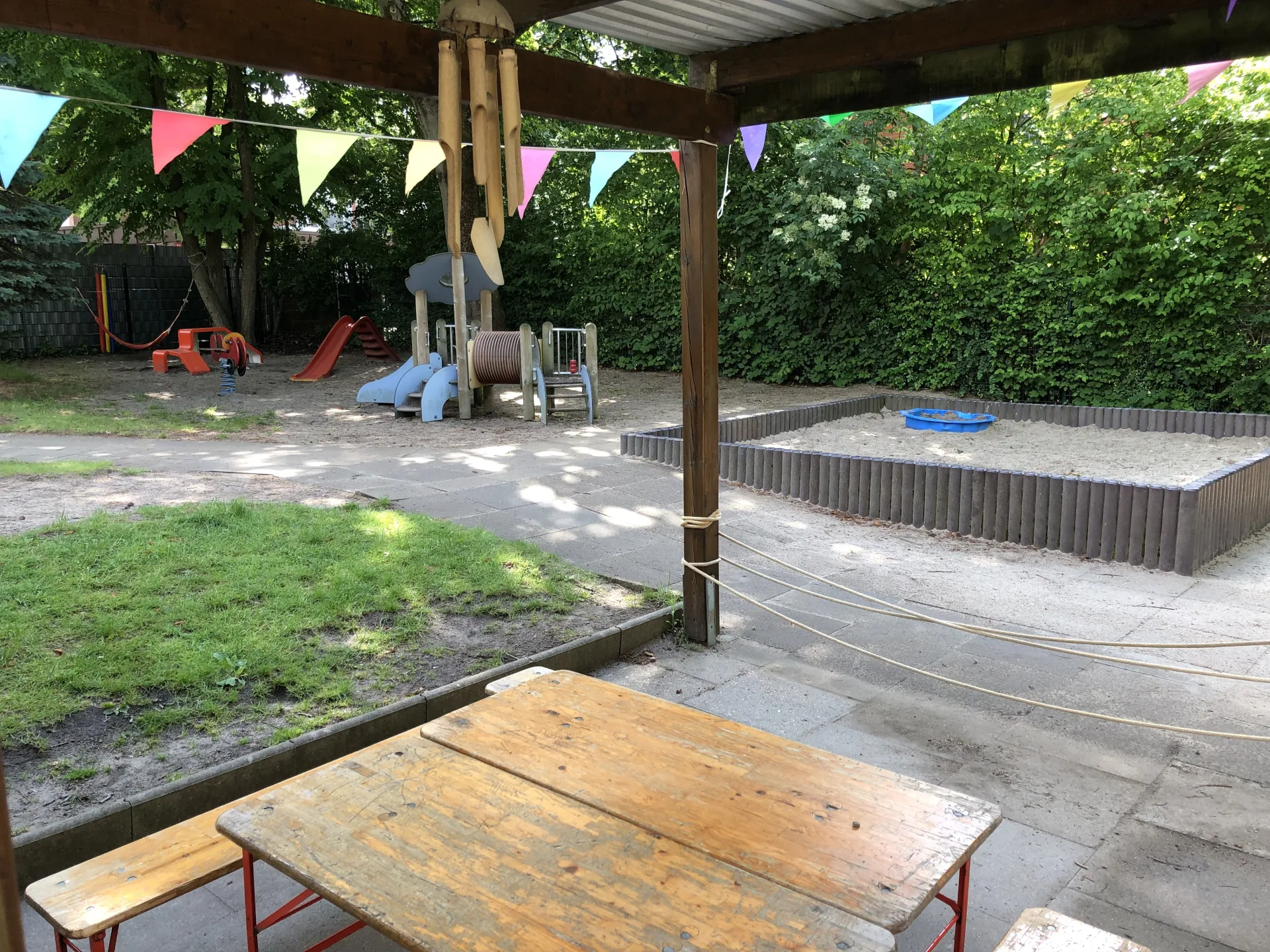 Überdachter Außenbereich mit Spielplatz der Kita Pusteblume